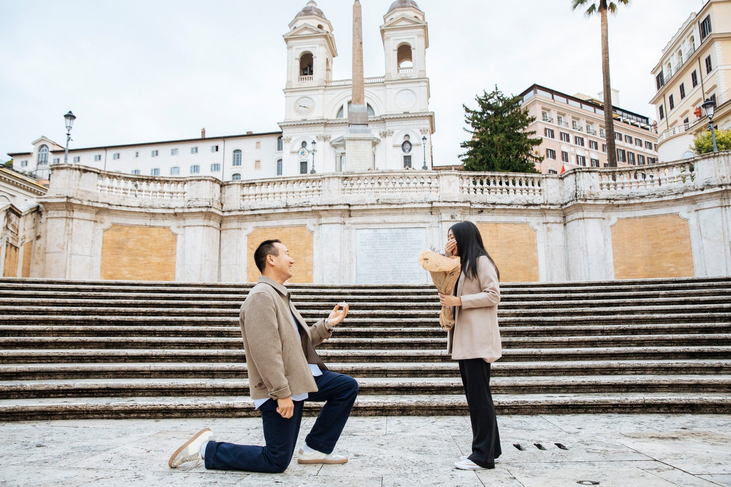 Kevin kneeling to propose to Kelly at the Spanish Steps