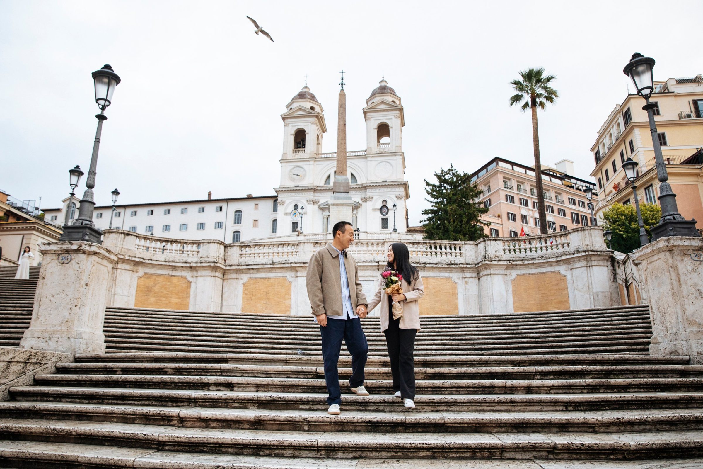 Kelly and Kevin walking hand in hand down the Spanish Steps in Rome